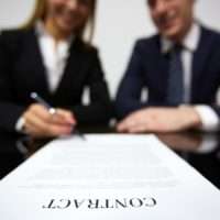 woman signing a long contract in distance