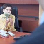 business woman counting money in office
